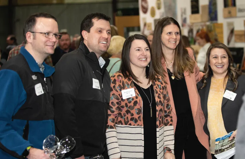 A group of people gathered at the wine festival smiling together.